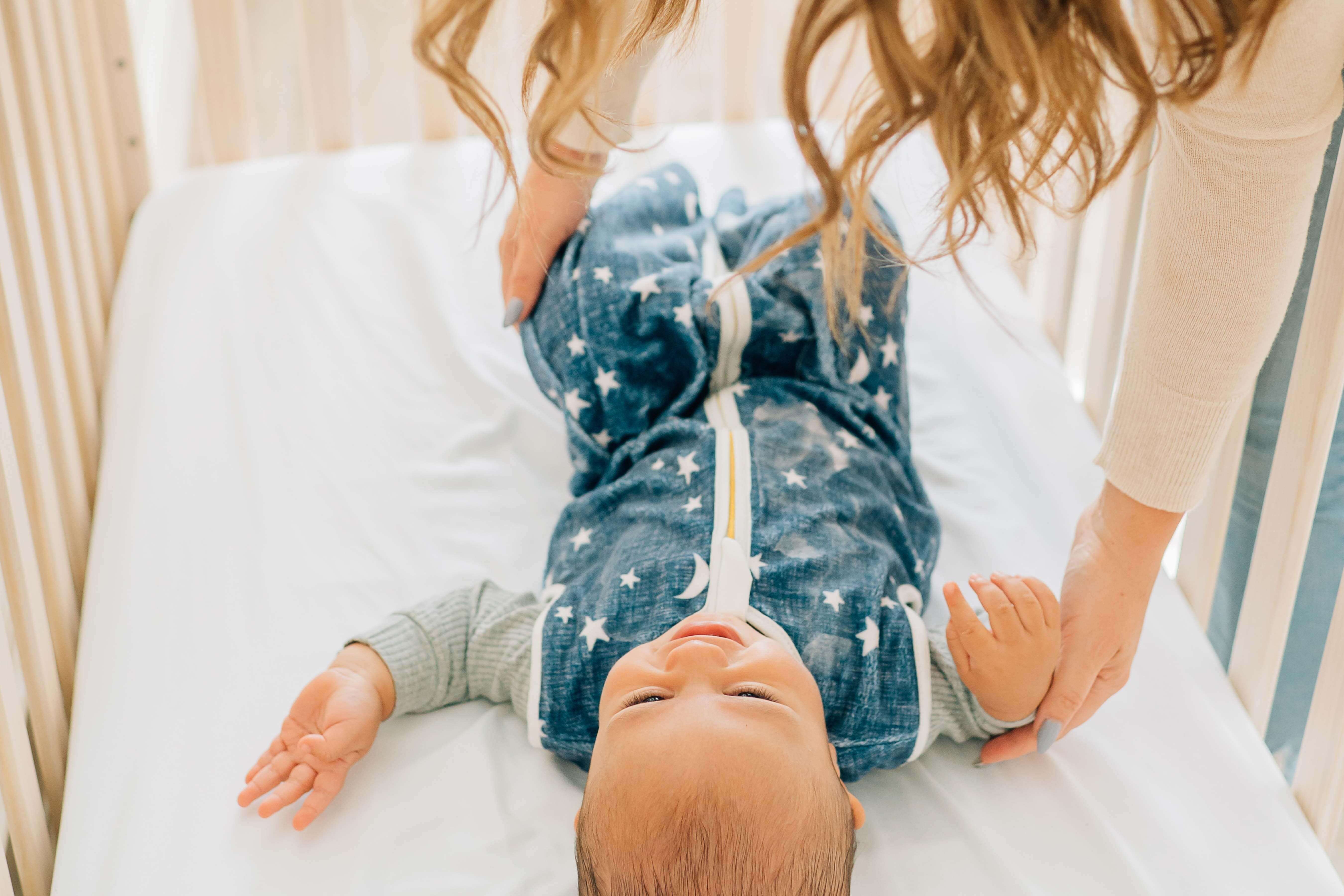 Navy Stars and Moons Wearable Minky Blanket on a baby in a crib, providing safe sleep alternative.