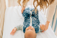 Navy Stars and Moons Wearable Minky Blanket on a baby in a crib, providing safe sleep alternative.