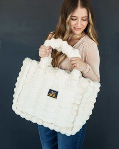 Annie Bag Ripple Cream held by a model, showcasing its luxurious texture and stylish design.