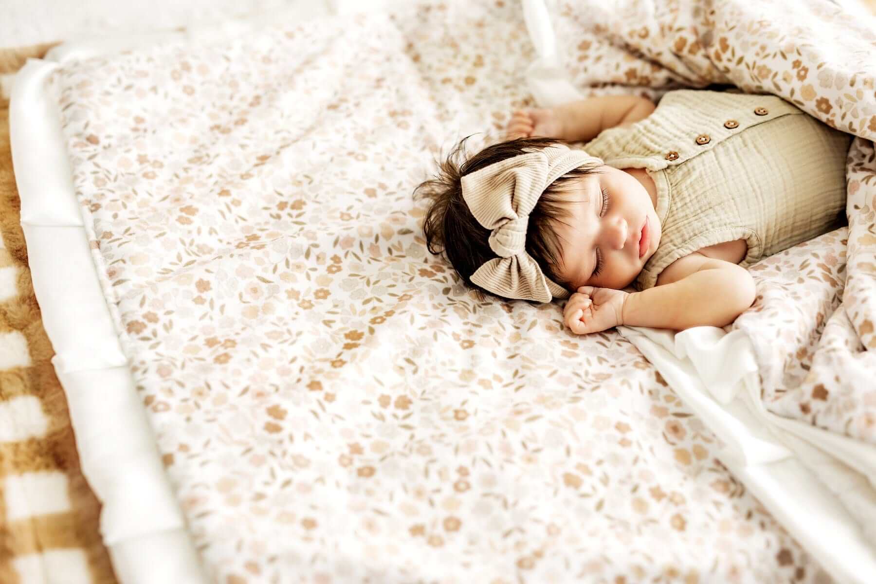Baby girl laying wrapped up in a Minky Couture Dainty floral print blanket.