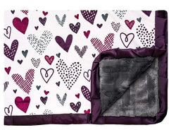 Love Notes Plum Minky Couture designer blanket laying flat with edge turned up. Doodled purple hearts with charcoal faux fur back and plum satin ruffle. 