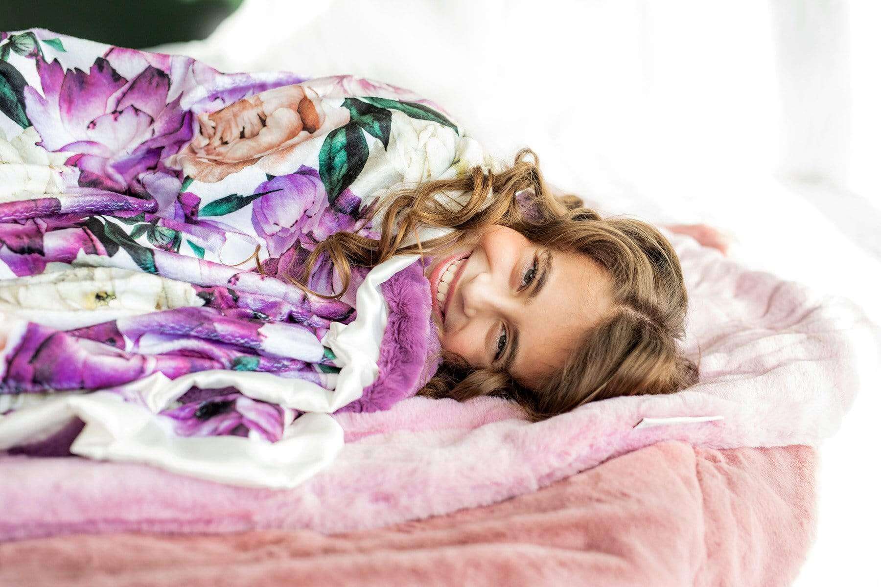 Girl snuggled up in the Purple Promise blanket by Minky Couture.