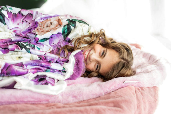 Girl snuggled up in the purple promise blanket by Minky Couture.