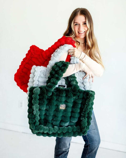 Annie Bags showcased in colorful plush textures held by a smiling model, highlighting luxurious style.