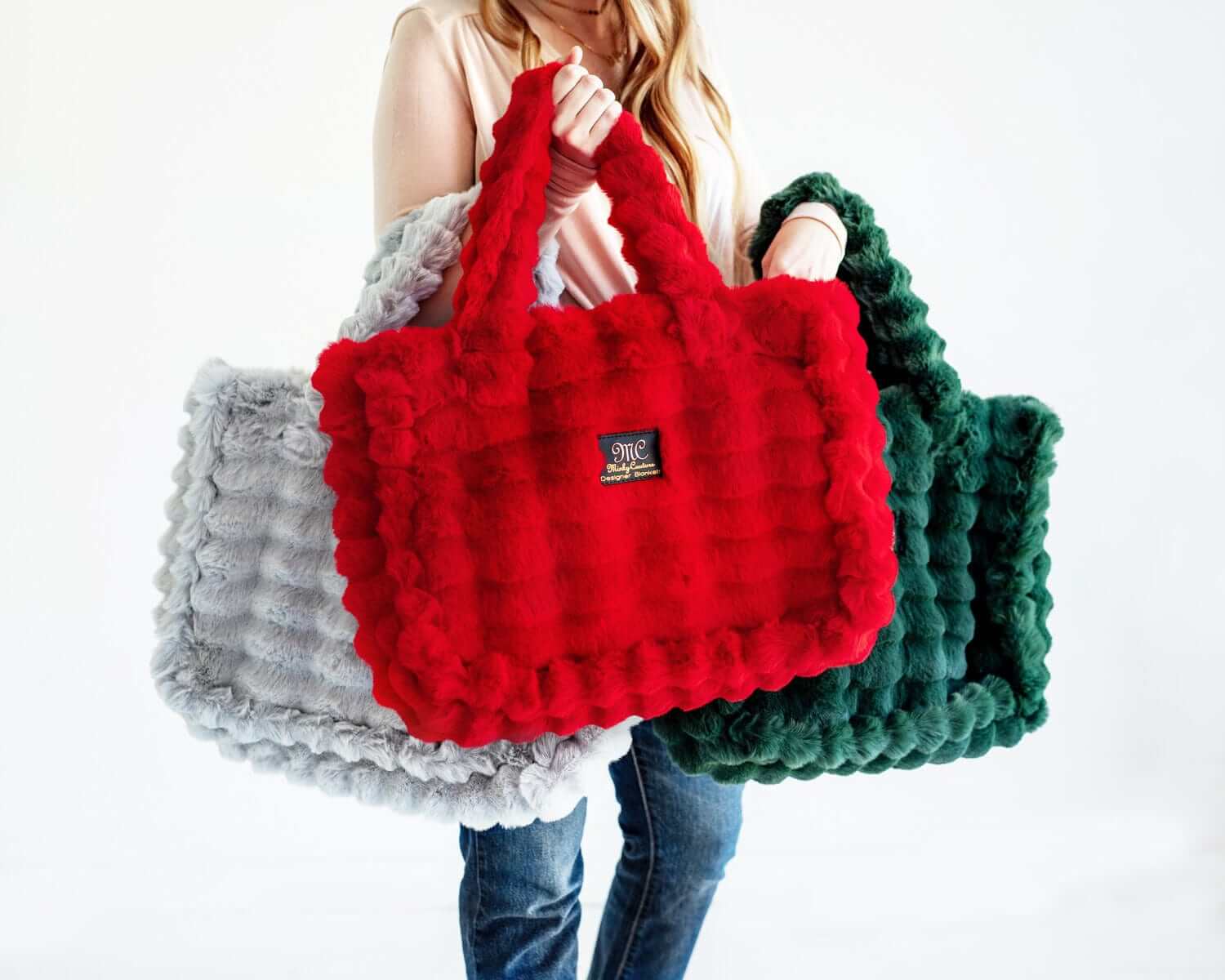 Minky Couture Annie Bags showcased in red, green, and silver colors, highlighting luxurious style and texture.